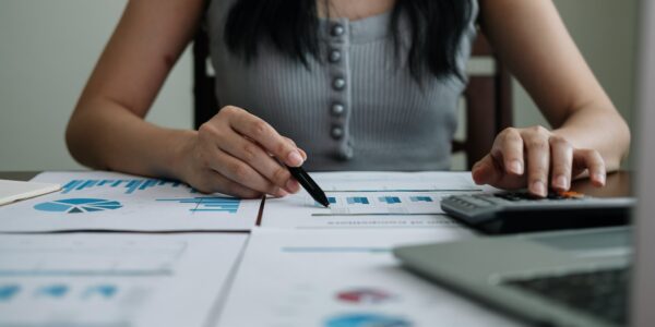 Business woman working in finance and accounting Analyze financial budget with calculator and