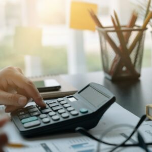 Business woman working in finance and accounting Analyze financial budget with calculator in the