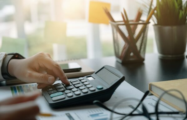Business woman working in finance and accounting Analyze financial budget with calculator in the