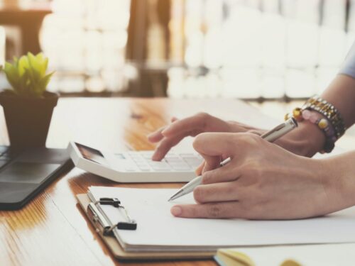 Close up of female accountant or banker making calculations. Savings, finances and economy concept