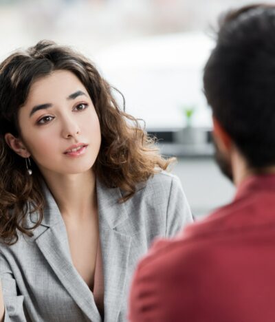 selective focus of account manager talking with colleague in office