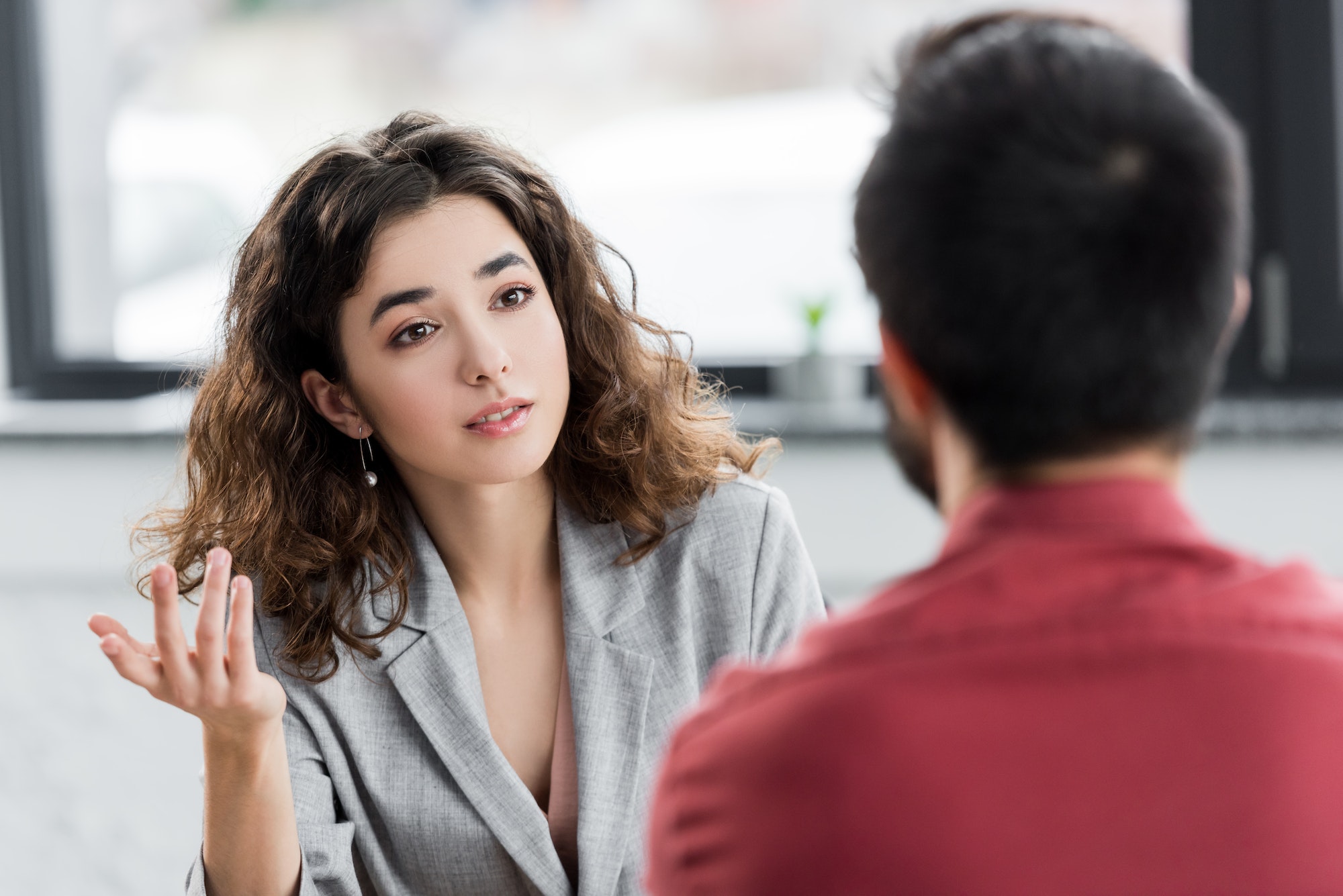 selective focus of account manager talking with colleague in office